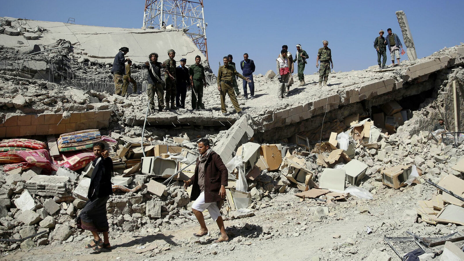 Policemen stand on the rubble of the police headquarters after it was destroyed by Saudi-led airstrikes in Sanaa, Yemen, Monday, Jan. 18, 2016. (AP Photo/Hani Mohammed)