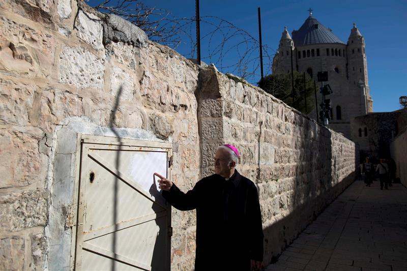 A monk points to a spot where graffiti was left near Dormition Abbey in the Old City of Jerusalem, 17 January 2016. Vandals sprayed anti-Christian graffiti overnight there, writing in Hebrew in several locations outside Dormition Abbey in Jerusalem. (EFE/EPA/ABIR SULTAN)