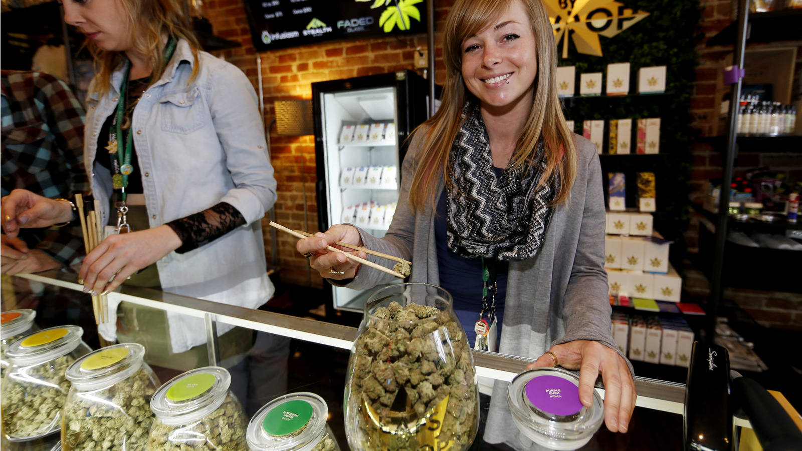 LivWell store manager Carlyssa Scanlon shows off some of the products available in the marijuana line marketed by rapper Snoop Dogg in one of the marijuana chain's outlets south of downtown Denver. LivWell grows the Snoop pot alongside many other strains on its menu. (AP Photo/David Zalubowski)