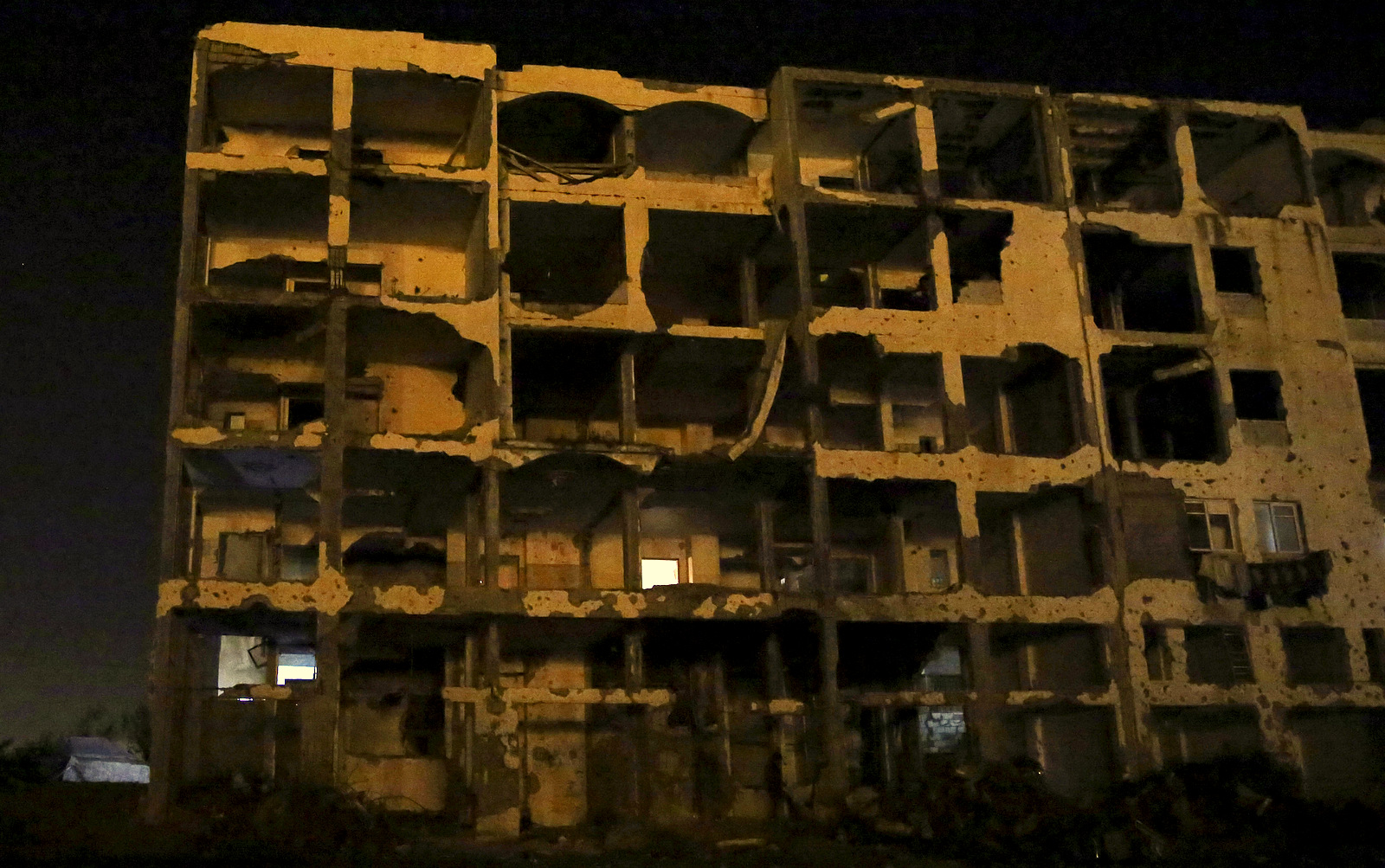 An apartment block, which was destroyed during the 2014 Israeli assault on Gaza is lit by LED lamps, during a power outage in Beit Lahiya, Gaza Strip. Electricity is available for as little as three hours a day in Gaza, and gas used for heating and cooking is in short supply. (AP Photo/Adel Hana)