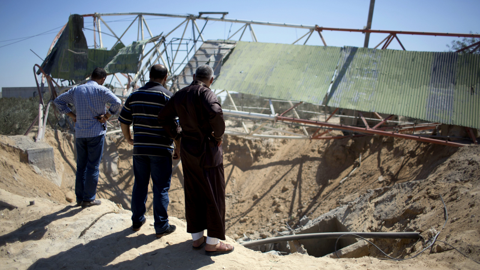 Palestinians look at damage caused by an Israeli airstrike on what the Israeli government claims was a Hamas training camp in Jabaliya, northern Gaza Strip, Saturday, Sept. 19, 2015. (AP Photo/ Khalil Hamra)
