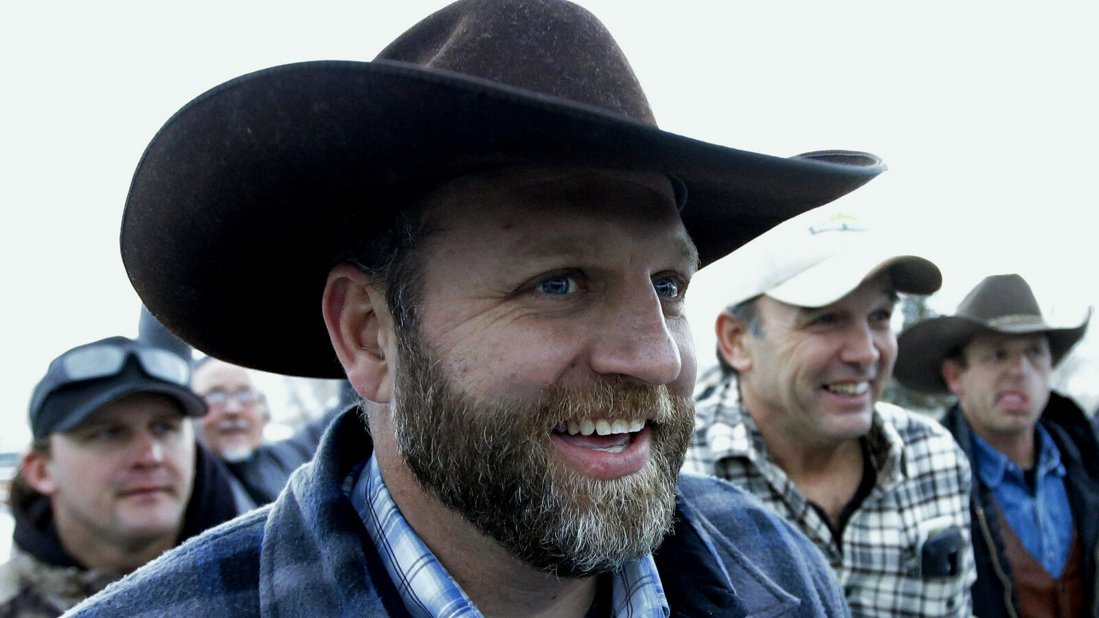 Ammon Bundy, one of the sons of Nevada rancher Cliven Bundy, smiles as he arrives for a news conference at Malheur National Wildlife Refuge after meeting with Harney County Sheriff David Ward Thursday, Jan. 7, 2016, near Burns, Ore. Ward and two other Oregon sheriffs met Thursday with Bundy, the leader of an armed group occupying a federal wildlife refuge and asked them to leave, after residents made it clear they wanted them to go home. (AP Photo/Rick Bowmer)