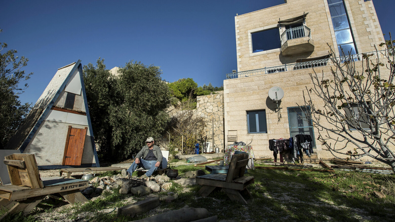 Moshe Gordon sits outside his guest house advertised on Airbnb international home-sharing site in Nofei Prat settlement in the Palestinian West Bank, Sunday, Jan. 17, 2016. (Photo: Tsafrir Abayov/AP)
