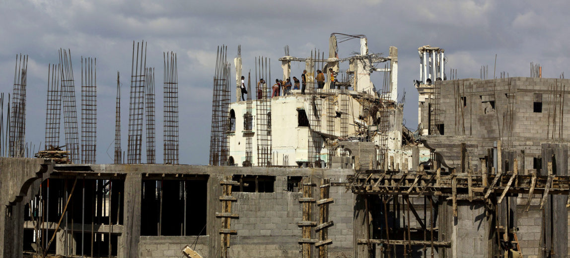 Palestinians work on rebuilding a home destroyed during last summer's Israeli assault on Gaza City. (AP Photo/Adel Hana)