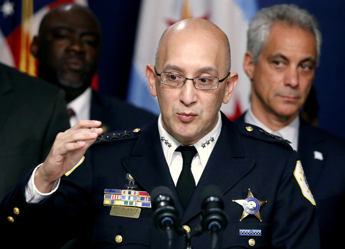 Chicago Police Superintendent John Escalante, left, speaks as Mayor Rahm Emanuel, right, listens, during a news conference in Chicago. As it scrambles to regain public trust shattered by the video of a black 17-year-old being shot 16 times by a white officer, the Chicago Police Department released crime statistics Friday, Jan. 1, 2016, that reveal a drop in some major crimes in the city but a significant increase in the number of homicides and shootings. Dec. 30, 2015. (AP Photo/Charles Rex Arbogast)