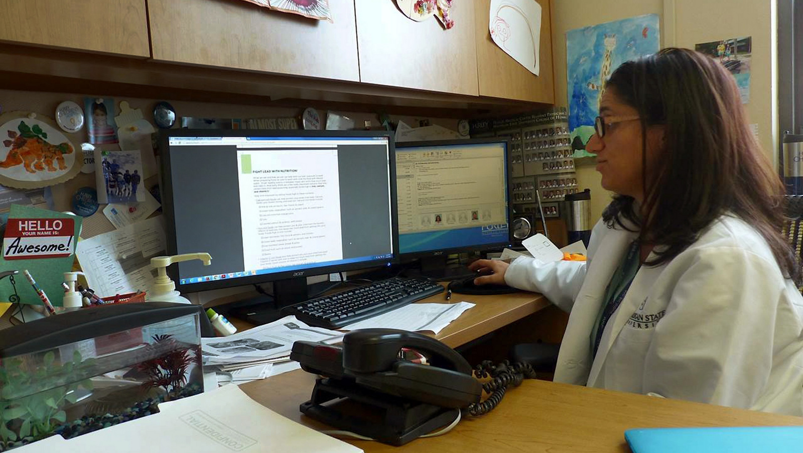 In a photo from Jan. 2, 2016, Dr. Mona Hanna-Attisha, director of pediatric residency at Hurley Children’s Hospital in Flint, Mich., works at her desk. The hospital is where more than 2,000 children have been tested for lead since the water switch was made in 2014. The doctor is credited with bringing the problem to the public’s attention even as state agencies dismissed her concerns. (AP Photo/Roger Schneider)