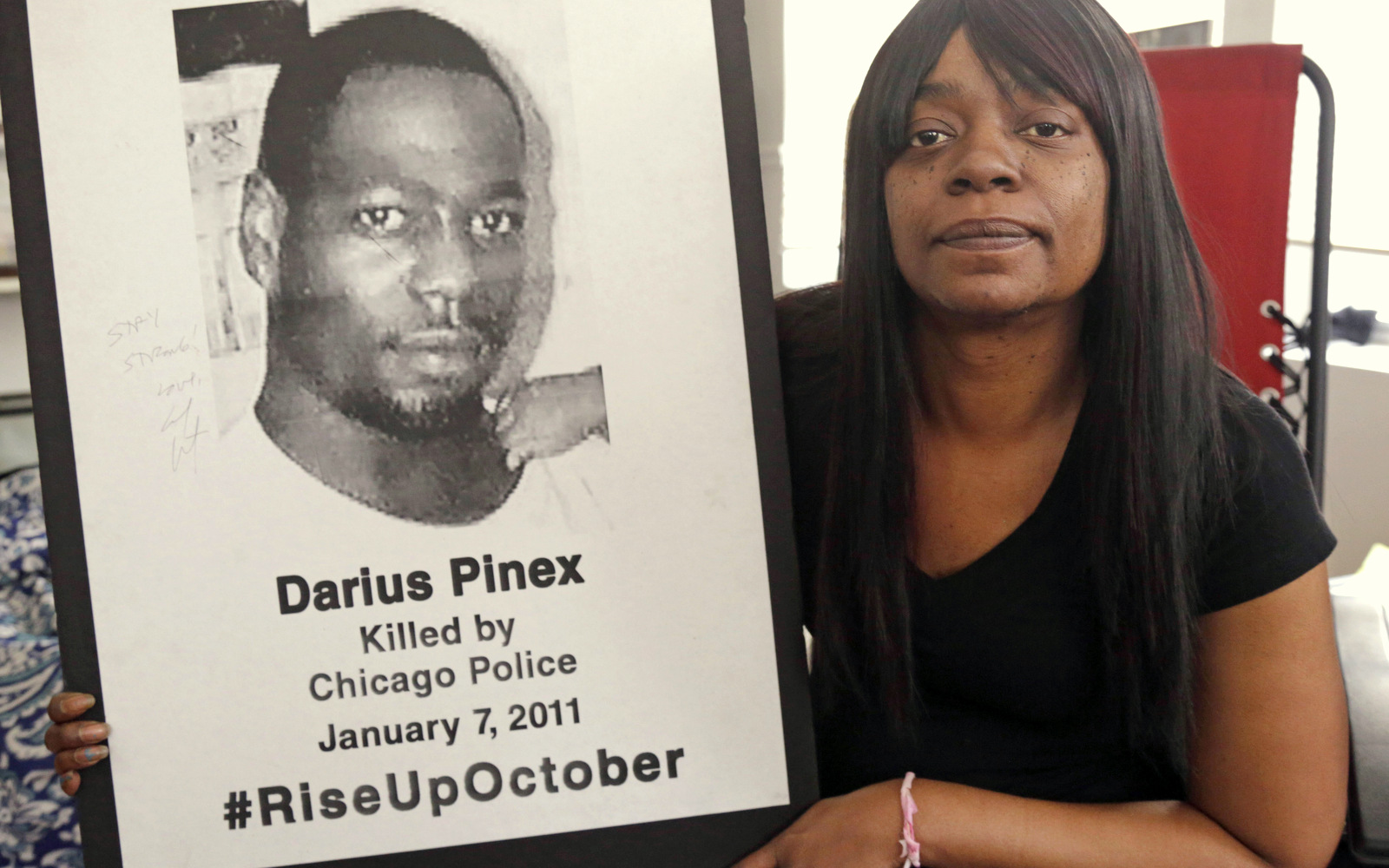Gloria Pinex holds a photo of her son, Darius Pinex, at her home in Chicago. Pinex sued the city after her son was killed by police in 2011 and on Monday, Jan. 4, 2016, a judge accused a city prosecutor of lying, prompting the city's law department to examine dozens of other cases the attorney worked on. (AP Photo/M. Spencer Green)