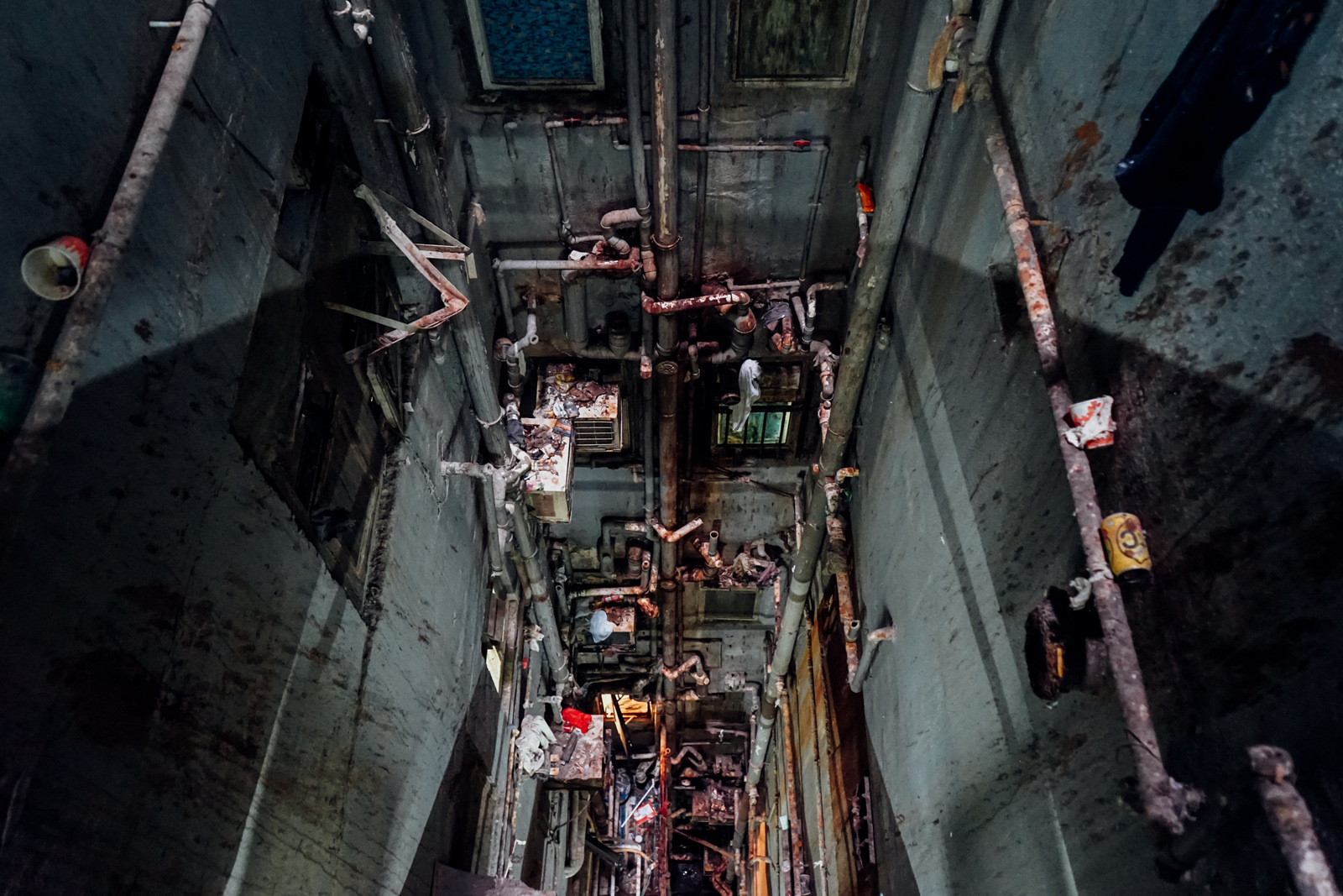 A glimpse of laundry, garbage and rusted pipes while looking down at a grimy interior courtyard of one of the towers of the Chungking Mansions in Hong Kong. (Zachary Senn)