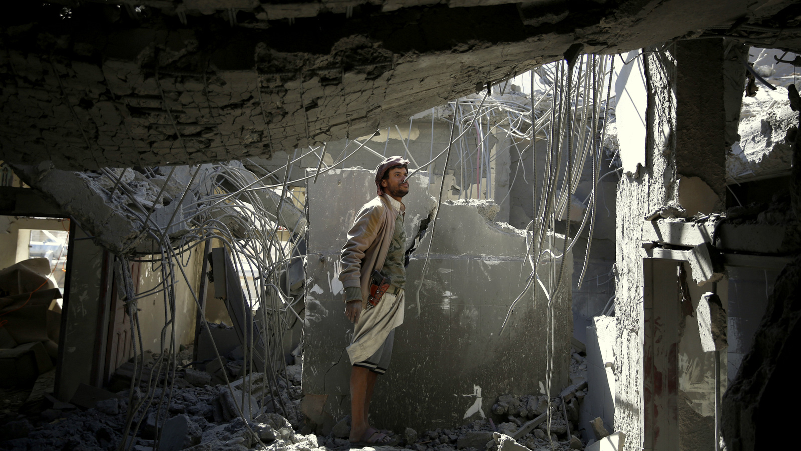 A man inspects his home destroyed by Saudi-led airstrikes in Sanaa, Yemen, Monday, Jan. 4, 2016. According to U.N. figures, the war in Yemen has killed at least 5,884 people since March, when fighting escalated after the Saudi-led coalition began launching airstrikes claiming to be targeting the Houthi rebels. (AP Photo/Hani Mohammed)