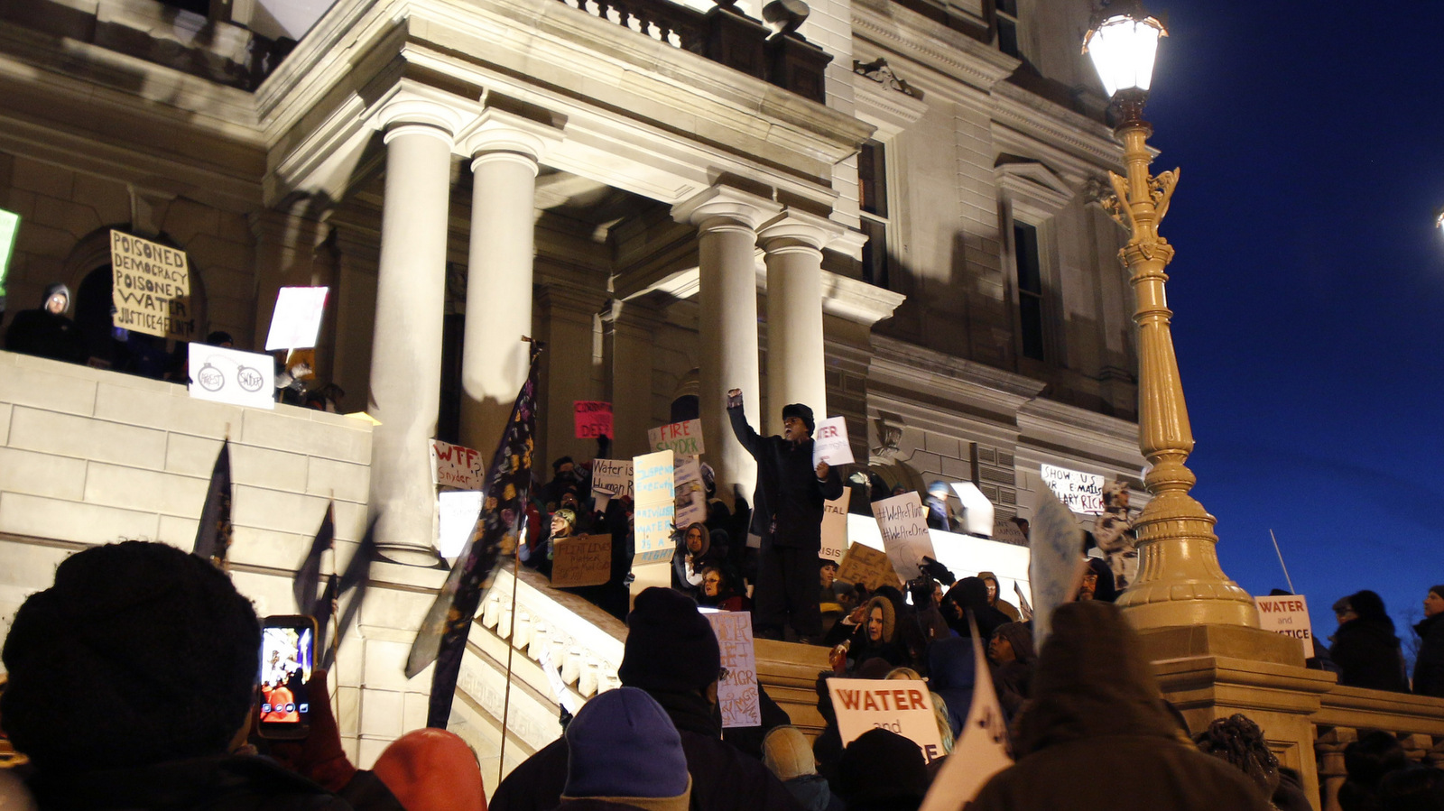 Protesters gather outside the state Capitol before Michigan Gov. Rick Snyder's State of the State address, Tuesday, Jan. 19, 2016, in Lansing, Mich. With the water crisis gripping Flint threatening to overshadow nearly everything else he has accomplished, the Republican governor again pledged a fix Tuesday night during his annual State of the State speech. (AP Photo/Al Goldis)
