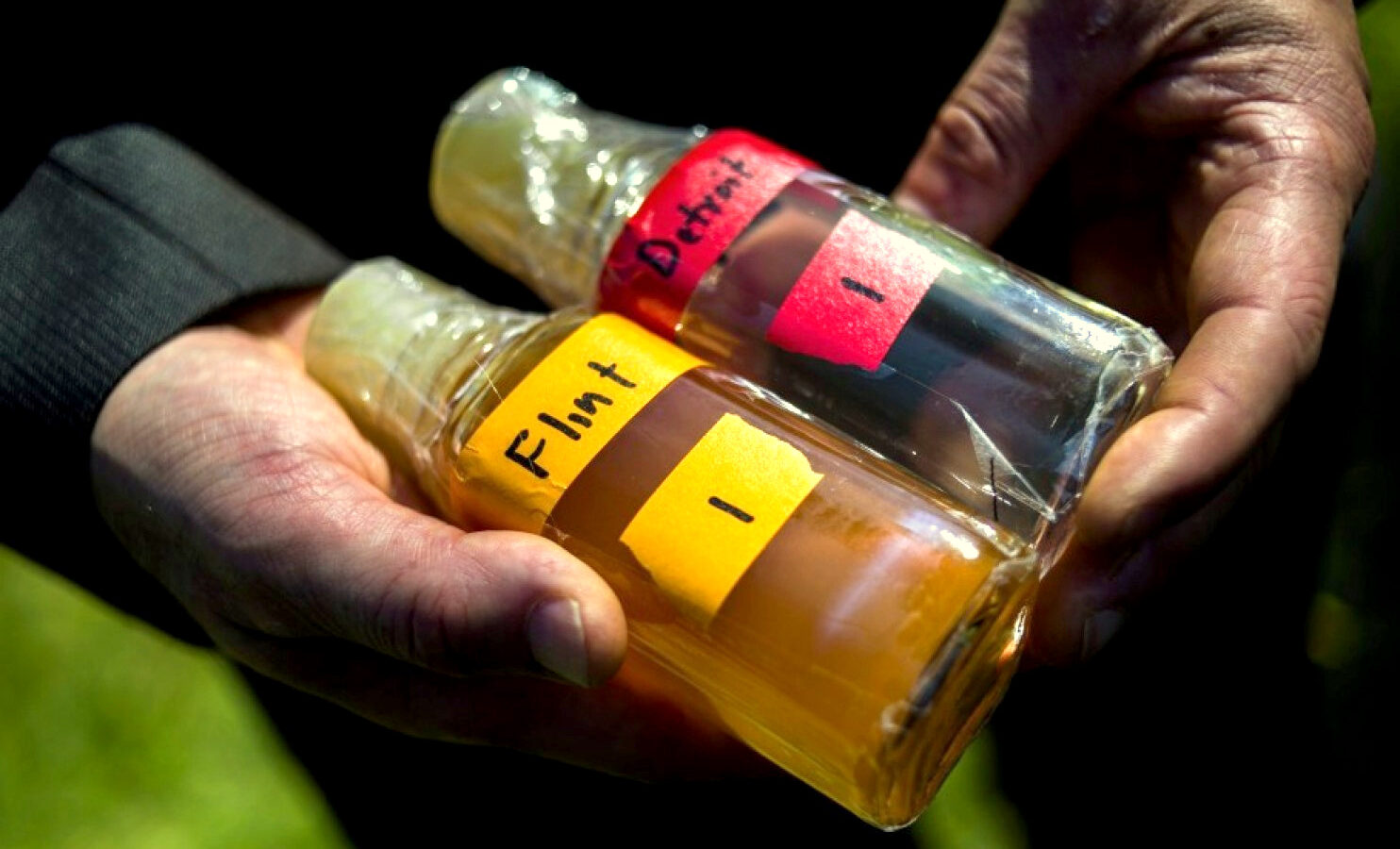Virginia Tech professor Marc Edwards shows the difference in water quality between Detroit and Flint after testing, giving evidence after more than 270 samples were sent in from Flint that show high levels of lead during a news conference on Tuesday, Sept. 15, 2015 outside of City Hall in downtown Flint, Mich. (Jake May/The Flint Journal via AP)