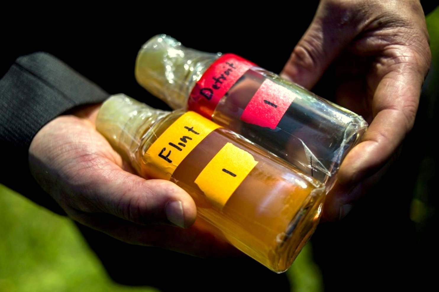 Virginia Tech professor Marc Edwards shows the difference in water quality between Detroit and Flint after testing, giving evidence after more than 270 samples were sent in from Flint that show high levels of lead during a news conference on Tuesday, Sept. 15, 2015 outside of City Hall in downtown Flint, Mich. (Jake May/The Flint Journal via AP)
