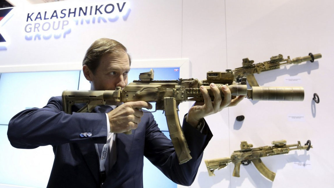 Russian Industry and Trade Minister Denis Manturov aims a weapon during the International Defense Exhibition (IDEX) in Abu Dhabi.Russian Industry and Trade Minister Denis Manturov aims a weapon during the International Defense Exhibition (IDEX) in Abu Dhabi.