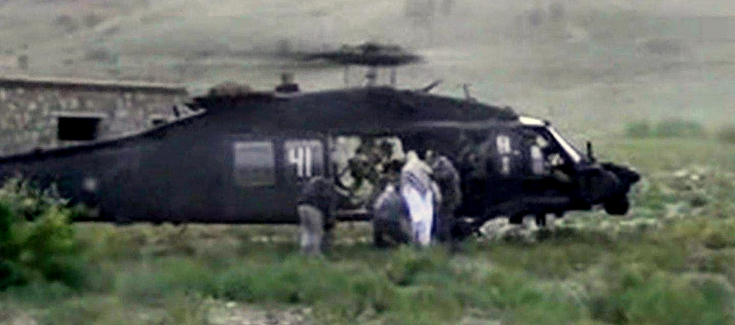 This image taken from video obtained from Voice Of Jihad Website shows men in civilian clothing leading Sgt. Bowe Bergdahl, in white, towards a helicopter in eastern Afghanistan. Bergdahl was freed on May 31, 2014. As Bergdahl was being loaded onto a U.S. chopper, near the border of Afghanistan and Pakistan, five Taliban detainees were freed from the Guantánamo prison and flown to Qatar.