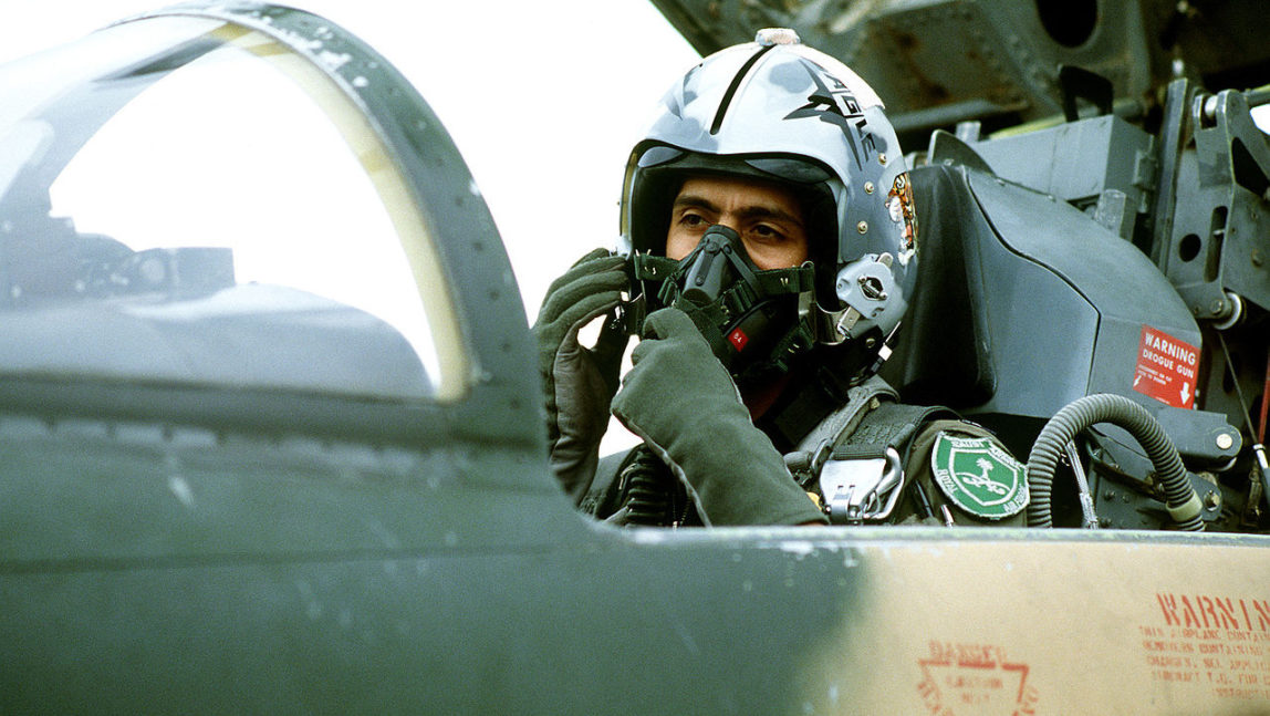 A Royal Saudi Arabian Air Force pilot adjusts his oxygen mask while in the cockpit of a an American-made F-5 Tiger II aircraft prior to flying a training mission at Williams Air Force Base.