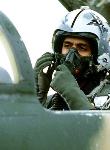 A Royal Saudi Arabian Air Force pilot adjusts his oxygen mask while in the cockpit of a an American-made F-5 Tiger II aircraft prior to flying a training mission at Williams Air Force Base.