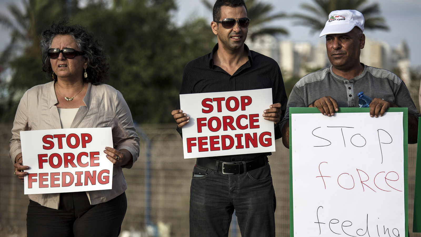 In this Tuesday, August 11, 2015 file photo, Israeli Arab supporters of Mohammed Allan, a Palestinian prisoner on a hunger strike, hold signs during a rally outside Barzilai hospital, in the costal city of Ashkelon, Israel. (AP Photo/Tsafrir Abayov, File)