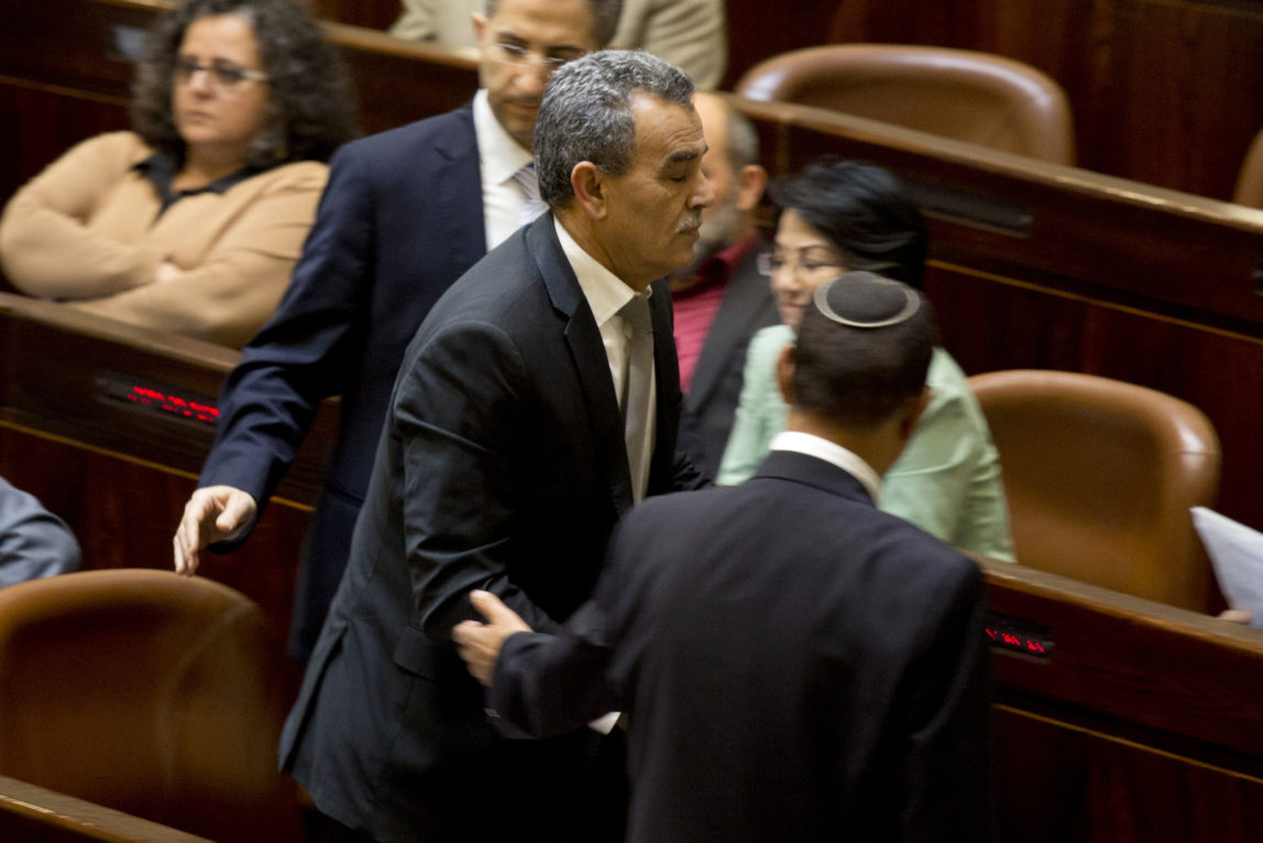 Jamal Zahalka an Israeli-Arab lawmaker from the Joint Arab List, is taken from the plenum in the Knesset, Israel's parliament in Jerusalem, Monday, Feb. 8, 2016. Israel’s government is promoting legislation to ban three Arab lawmakers who met with families of Palestinians who carried out deadly attacks. The Arab parliamentarians, Hanin Zoabi, Basel Ghattas and Jamal Zahalka, met the families last week to help lobby the release of some of their relatives’ bodies. (AP Photo/Ariel Schalit)