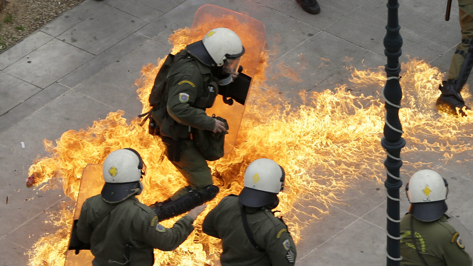 Riot policemen try to avoid a petrol bomb thrown by protesters during a 24-hour nationwide general strike in Athens, Thursday, Feb. 4, 2016. Clashes have broken out between Greek police and youths throwing fire bombs and stones, as tens of thousands of people march through central Athens to protest planned pension reforms.(AP Photo/Thanassis Stavrakis)