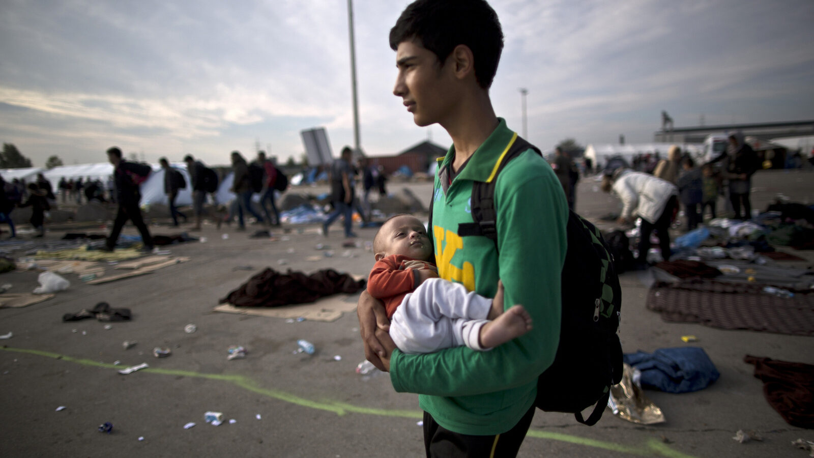 Afghan refugee Rasoul Nazari, 15, holds his 10-month-old nephew Imran after crossing the border between Hungary and Austria in Nickelsdorf, Austria. (AP Photo/Muhammed Muheisen)