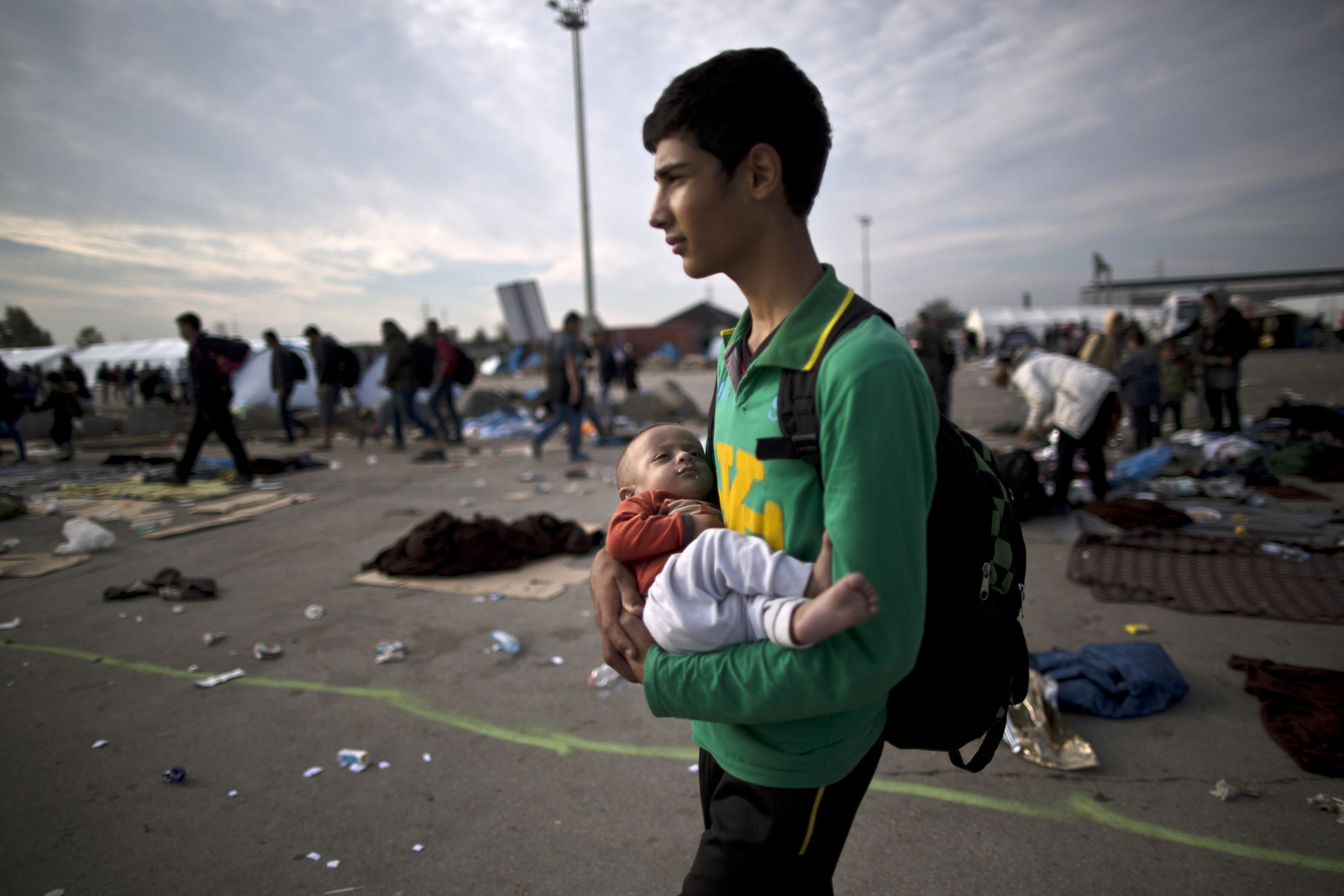Afghan refugee Rasoul Nazari, 15, holds his 10-month-old nephew Imran after crossing the border between Hungary and Austria in Nickelsdorf, Austria. (AP Photo/Muhammed Muheisen)