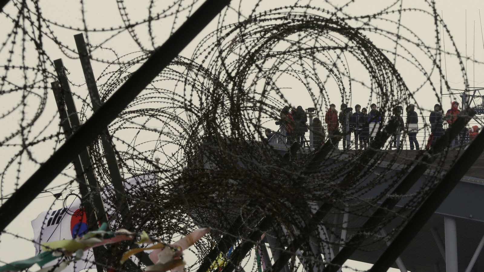 Visitors watching the North side are seen through barbed-wire entanglements as they visit Imjingak near the border village of the Panmunjom in Paju, South Korea, Monday, Feb. 8, 2016. The U.N. Security Council condemned North Korea's launch of a long-range rocket that world leaders called a banned test of ballistic missile technology and another "intolerable provocation." The U.N.'s most powerful body pledged to quickly adopt a new resolution with "significant" new sanctions. (AP Photo/Ahn Young-joon)