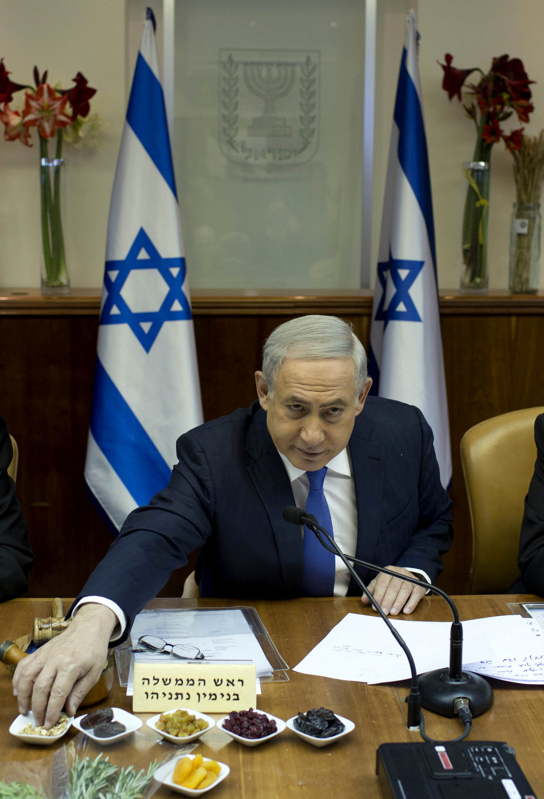 Israel's Prime Minister Benjamin Netanyahu, center, eats fruit during the weekly cabinet meeting, in Jerusalem, Sunday, Jan. 24, 2016. Netanyahu has demanded additional aid from the U.S. on top of the more than $3 Billion Israel already receives. (Abir Sultan/Pool Photo via AP)A