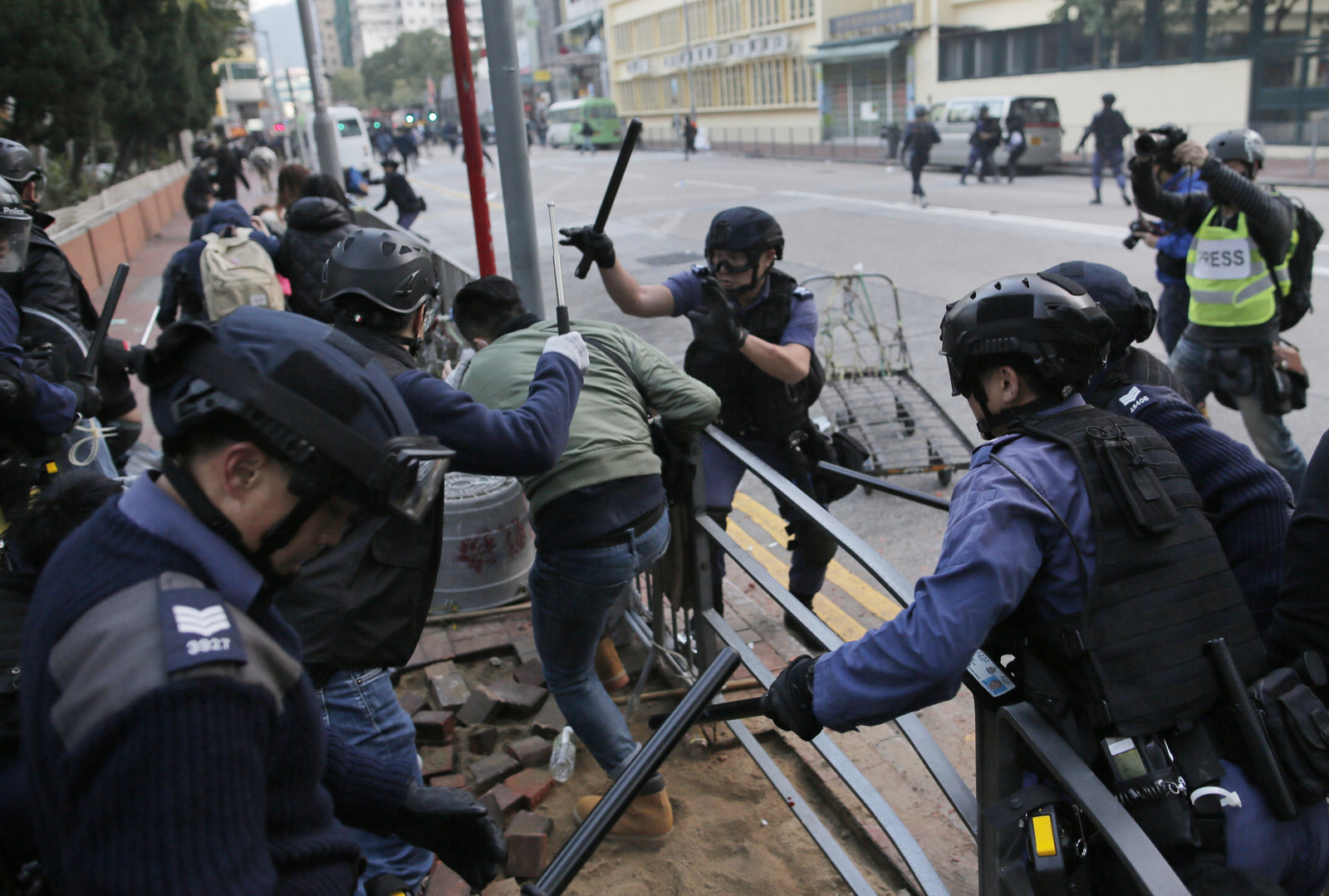 Riot police chase a protestor in Mong Kok district of Hong Kong, Tuesday, Feb. 9, 2016. (AP Photo/Vincent Yu)