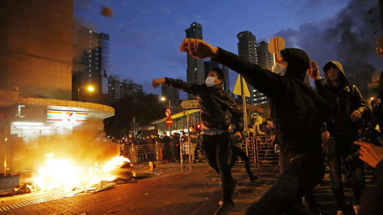 Protestors throw bricks at police and light fires on streets in Mongkok district of Hong Kong, Tuesday, Feb. 9, 2016. Protesters engaged in running battles with police, pelting officers with bricks and bottles and setting fires on the street Monday night and early Tuesday. (AP Photo/Kin Cheung)