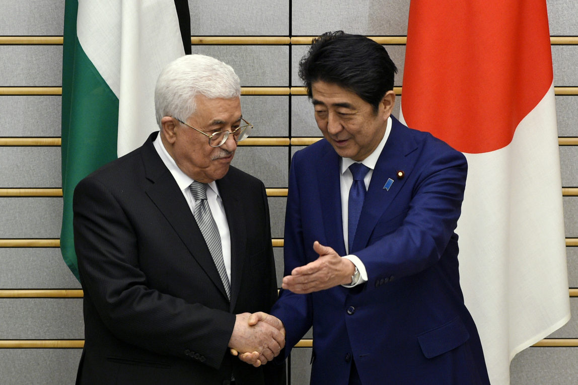 Palestinian President Mahmoud Abbas, left, shakes hands with Japanese Prime Minister Shinzo Abe prior to their meeting at Abe's official residence in Tokyo, Japan, Monday, Feb. 15, 2016. (Franck Robichon/AP)