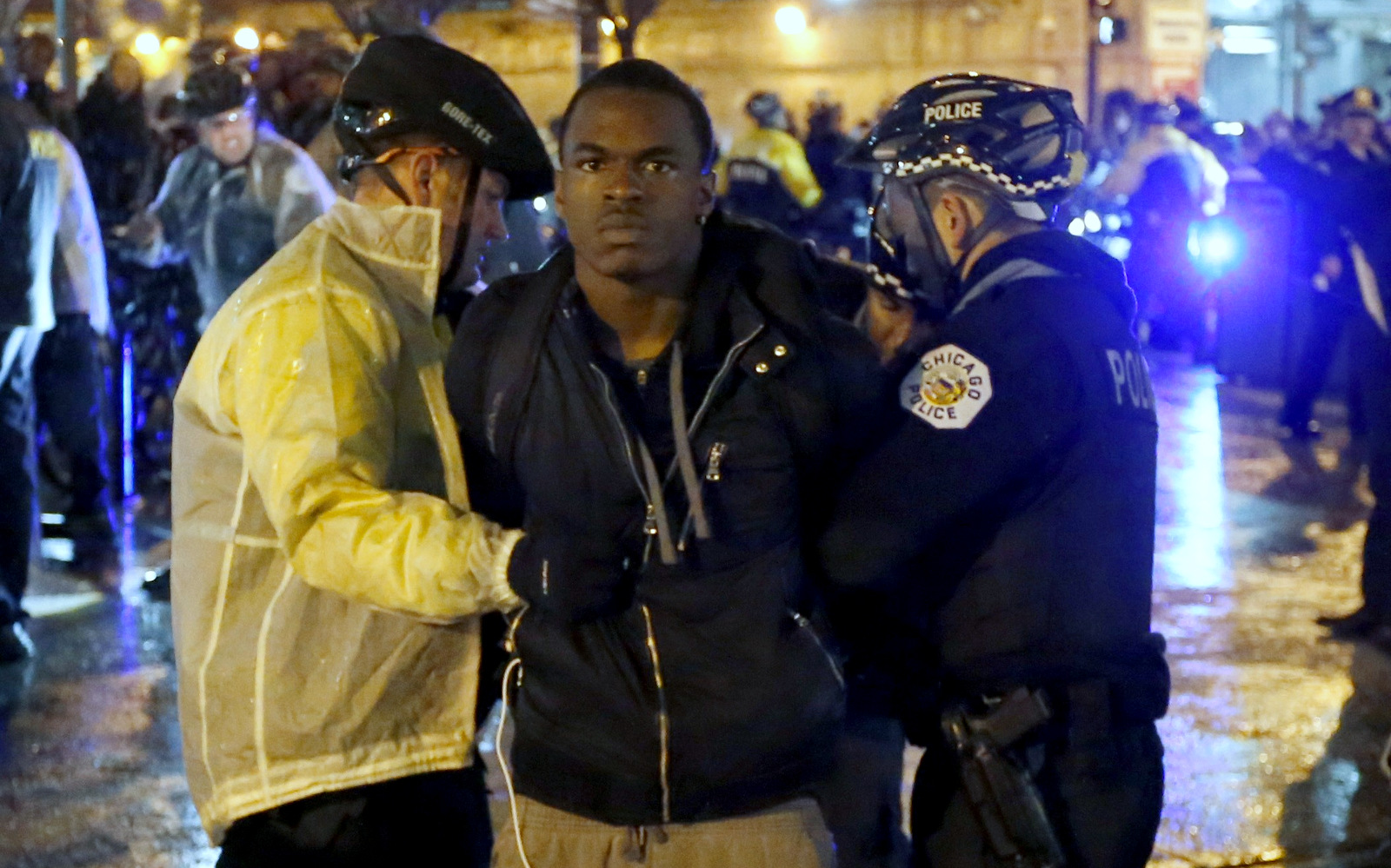 Two Chicago police officers take a man into custody during a protest march, Wednesday, Nov. 25, 2015, in Chicago, the day after murder charges were brought against police officer Jason Van Dyke in the killing of 17-year-old Laquan McDonald. (AP Photo/Charles Rex Arbogast)