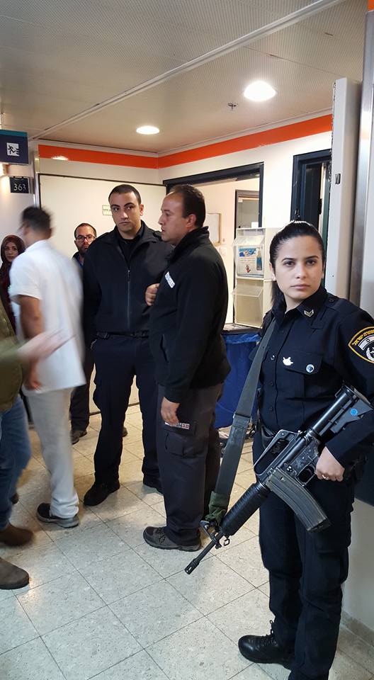 An armed Israeli police woman in front of Al-Qeeq’s room in Afula hospital.