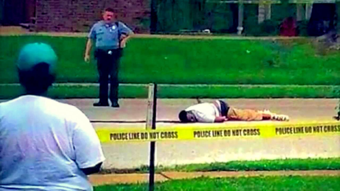 Michael Brown lays dead in the street after being shot and killed by police in Ferguson, Missouri.