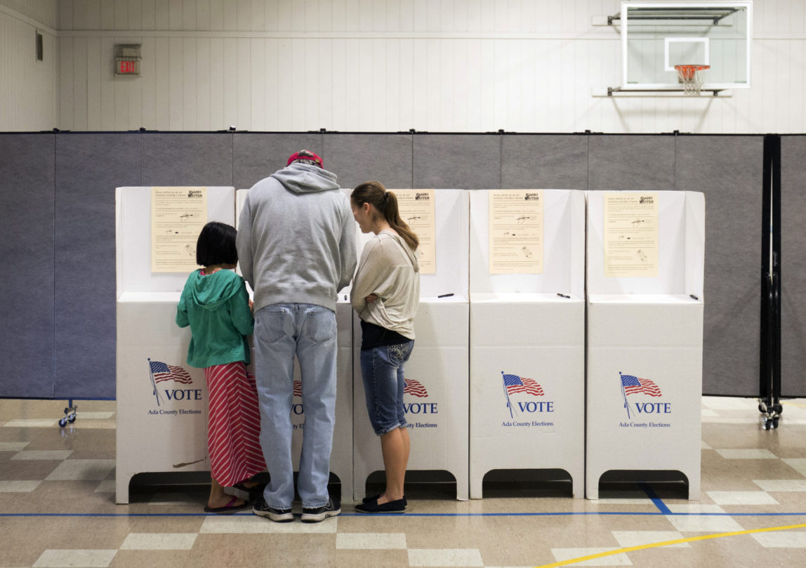 Troy Drake votes with two of his children during the primary election at Boise Bible College in Garden City, Idaho, on Tuesday, March 8, 2016. Idaho Republicans are headed to the polls to take part in the state's GOP presidential primary. (AP Photo/Otto Kitsinger)