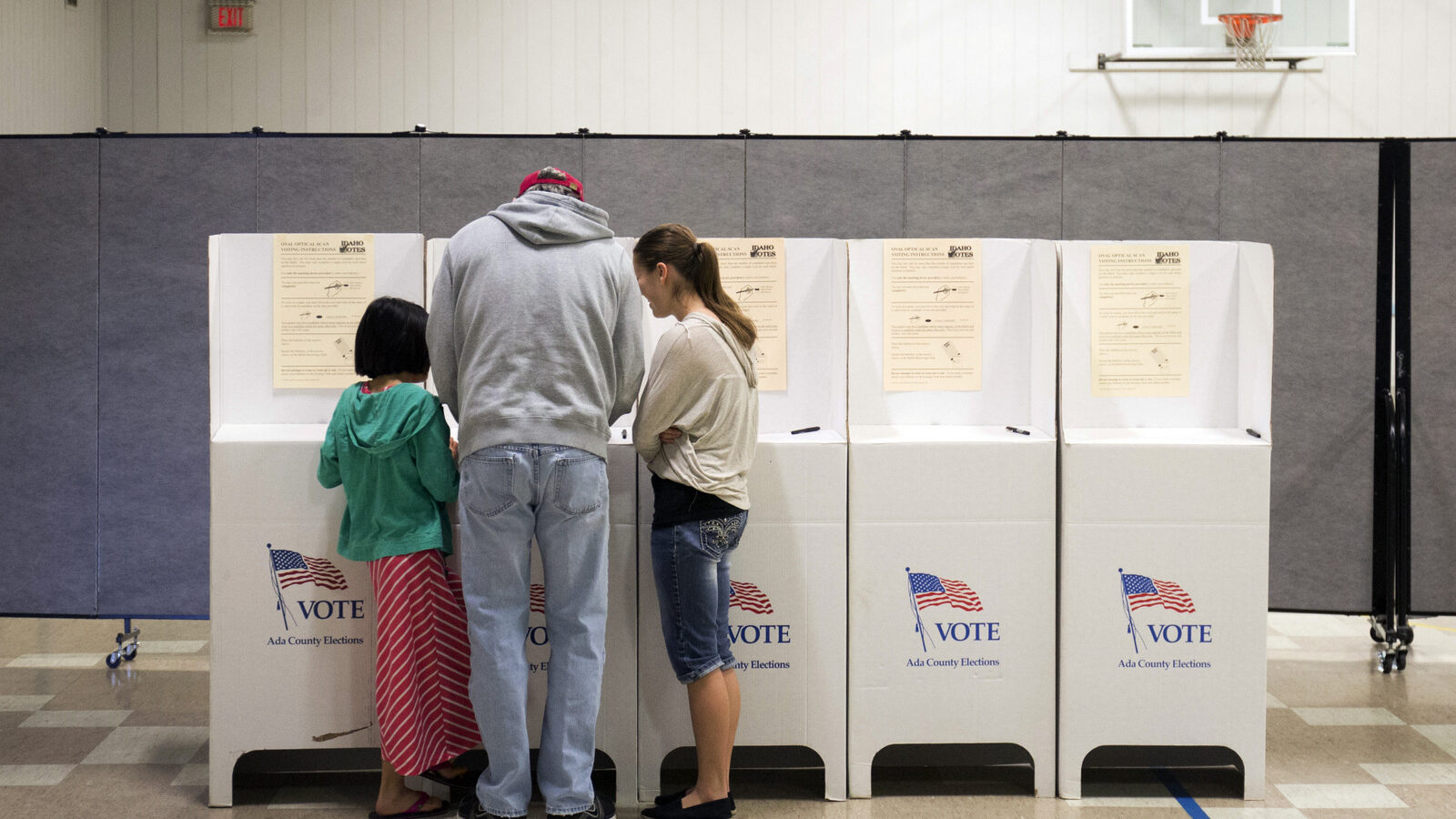 Troy Drake votes with two of his children during the primary election at Boise Bible College in Garden City, Idaho, on Tuesday, March 8, 2016. Idaho Republicans are headed to the polls to take part in the state's GOP presidential primary. (AP Photo/Otto Kitsinger)