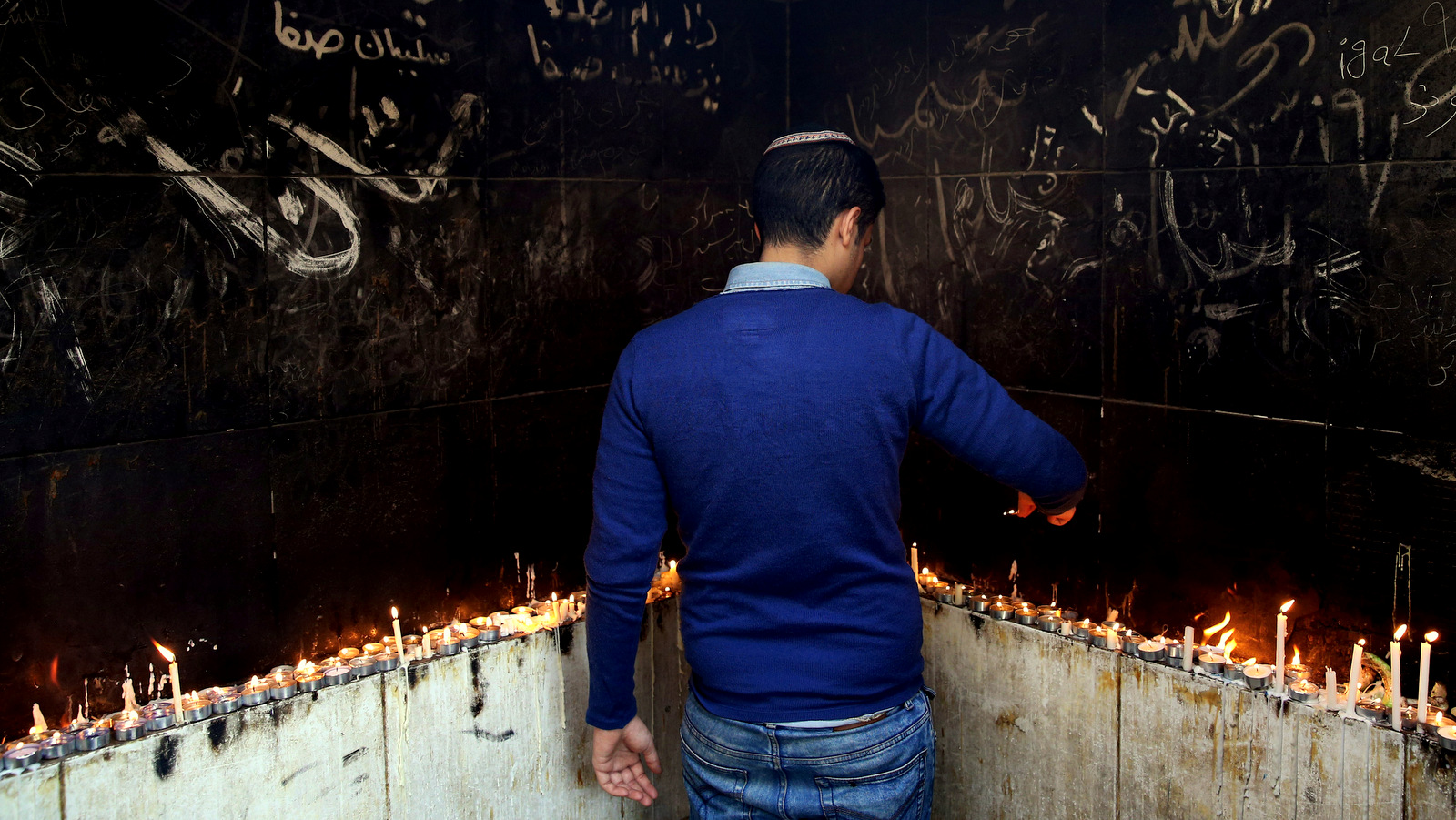 In this Thursday, Nov. 20, 2014 photo, an Iranian Jewish man lights candles at the at the tomb of Harav Oursharga, one of the holiest Jewish sites in Iran, in the city of Yazd 420 miles (676 kilometers) south of capital Tehran. More than a thousand people trekked across Iran this past week to visit a shrine in this ancient Persian city, a pilgrimages like many others in the Islamic Republic until you notice men there wearing yarmulkes. (AP Photo/Ebrahim Noroozi)
