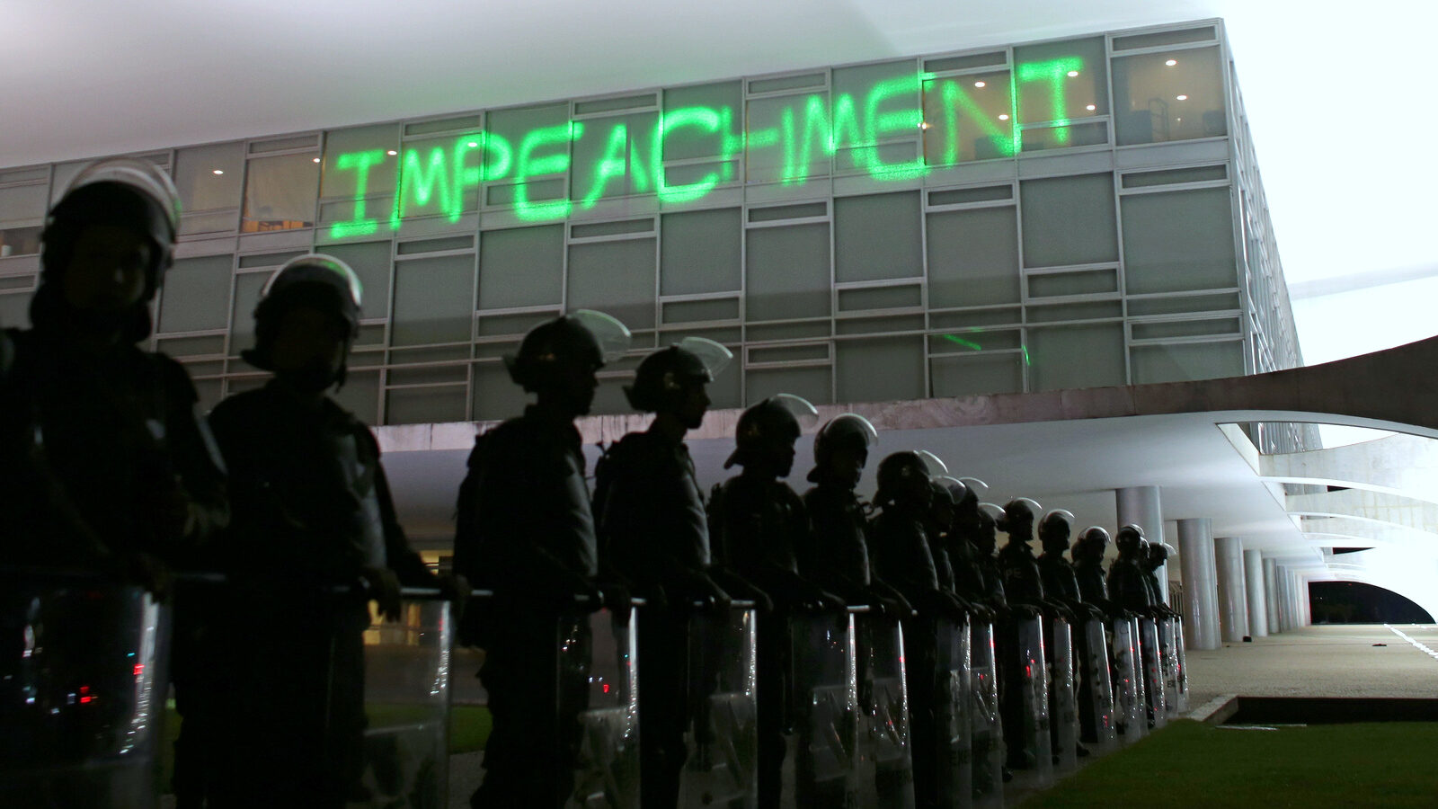 Soldiers stand guard outside Planalto presidential palace where protesters have projected the word "Impeachment" on the building, as they call for the impeachment of Brazil's President Dilma Rousseff in Brasilia, Brazil, Monday, March 21, 2016. (AP/Eraldo Peres)