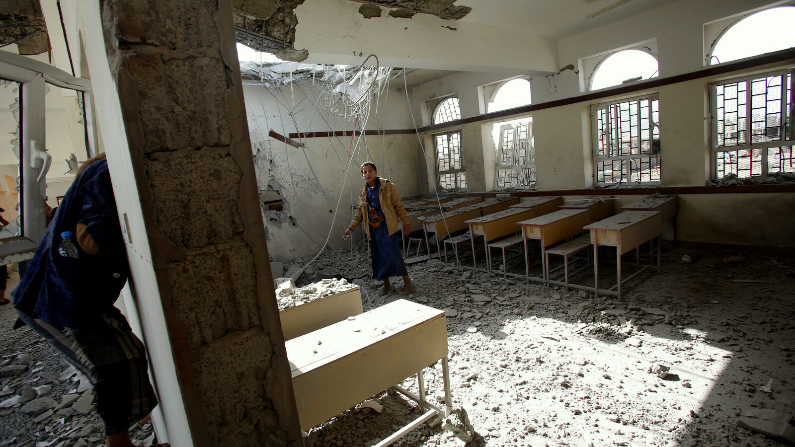 Boys walk around in a classroom at a school damaged by Saudi-led airstrikes in Sanaa, Yemen, Monday, July 20, 2015. The death toll in Yemen from the Shiite rebel shelling of a town near the southern port city of Aden rose on Monday to nearly 100, the head of an international aid group said, describing it as "the worst day" for the city and its surroundings in over three months of fighting. (AP Photo/Hani Mohammed)
