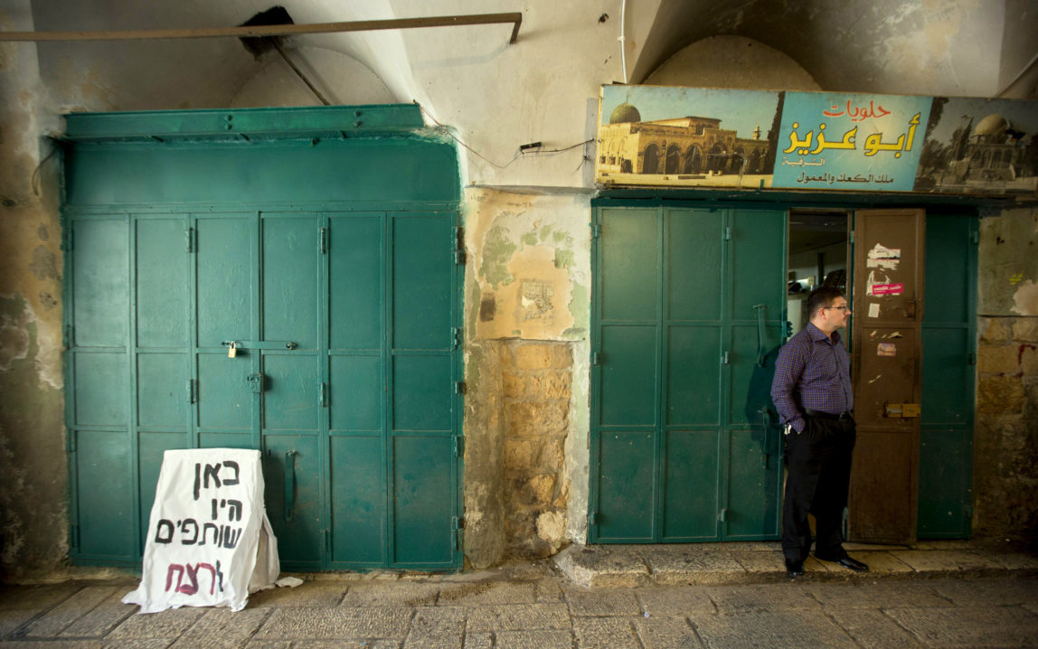 A Palestinian vendor stands outside his shop Jerusalem's Old City, Thursday, Oct. 8, 2015. (AP Photo/Sebastian Scheiner)