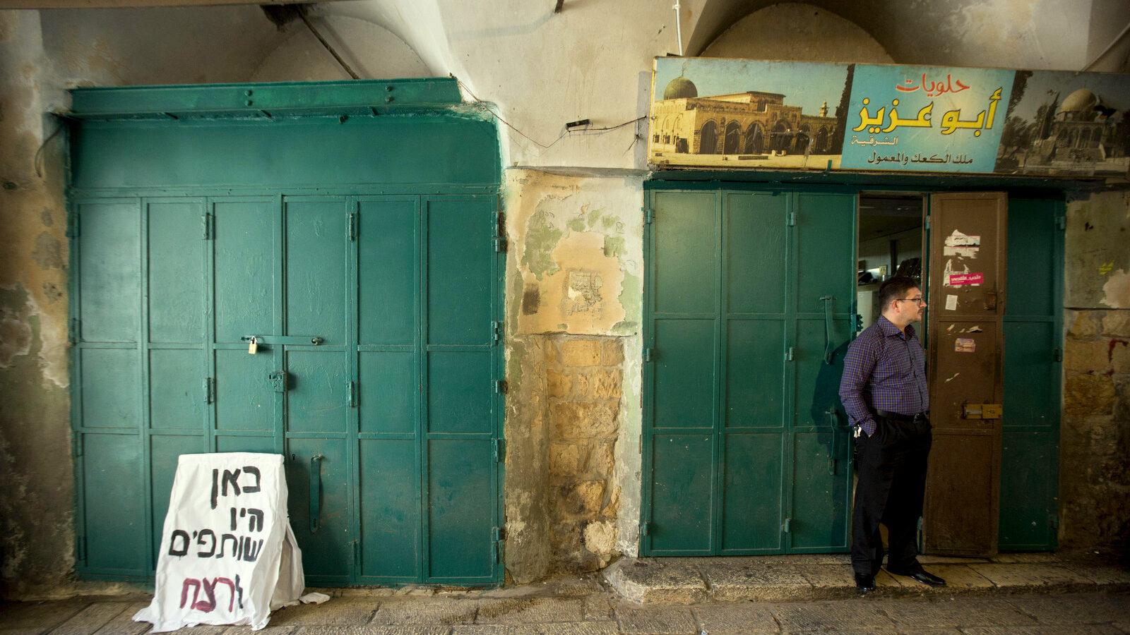 A Palestinian vendor stands outside his shop Jerusalem's Old City, Thursday, Oct. 8, 2015. (AP Photo/Sebastian Scheiner)