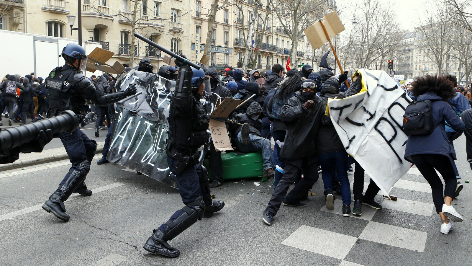 Youths clash with riot police officers during a high school students demonstration against a labor reform, in Paris, Thursday, March 24, 2016. France's Socialist government is due to formally present a contested labor reform that aims to amend the 35-hour workweek and relax other labor rules. (AP Photo/Francois Mori)
