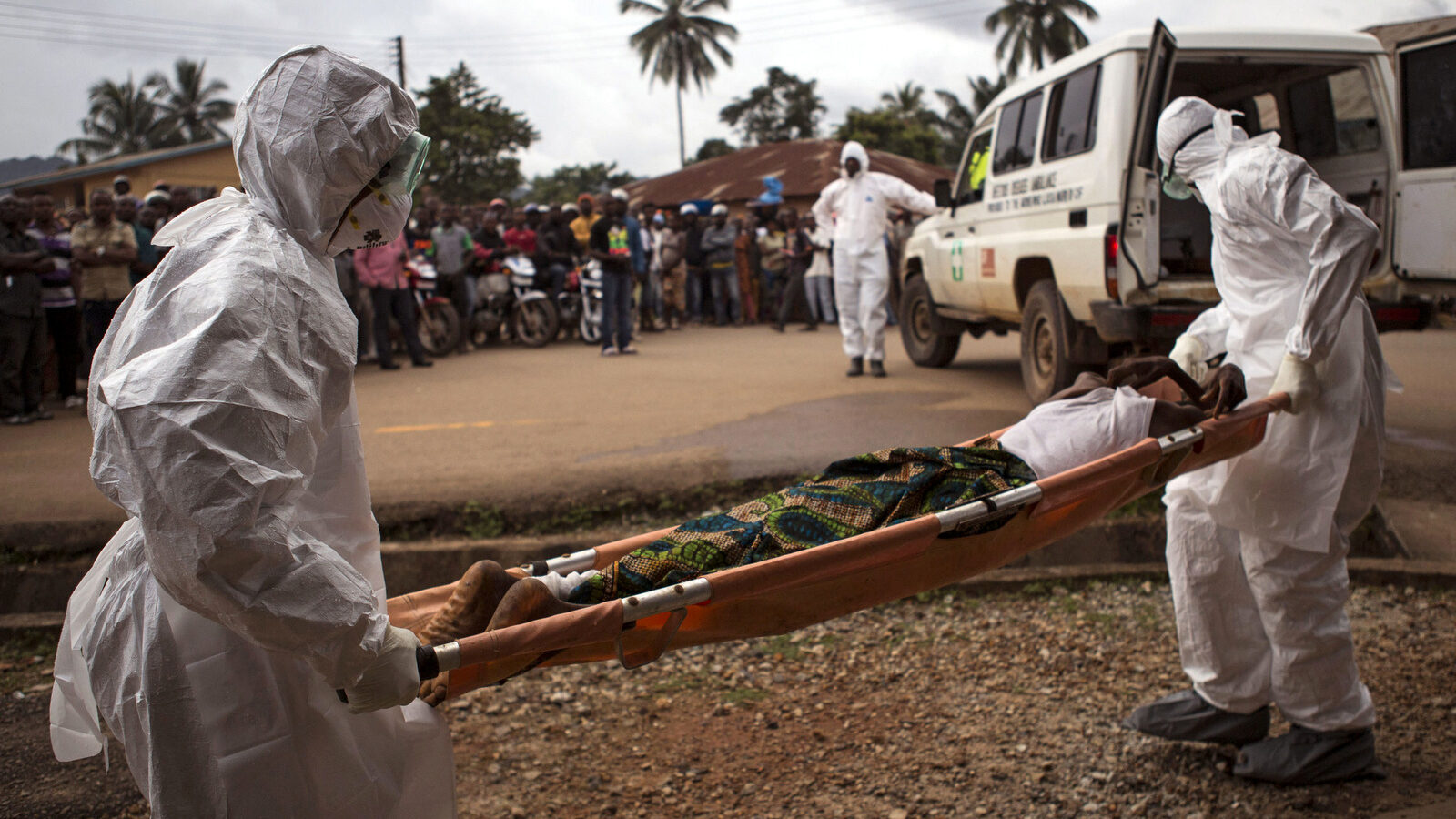 Healthcare workers load a man suspected of suffering from the Ebola virus onto an ambulance in Kenema, Sierra Leone. (AP Photo/Tanya Bindra)