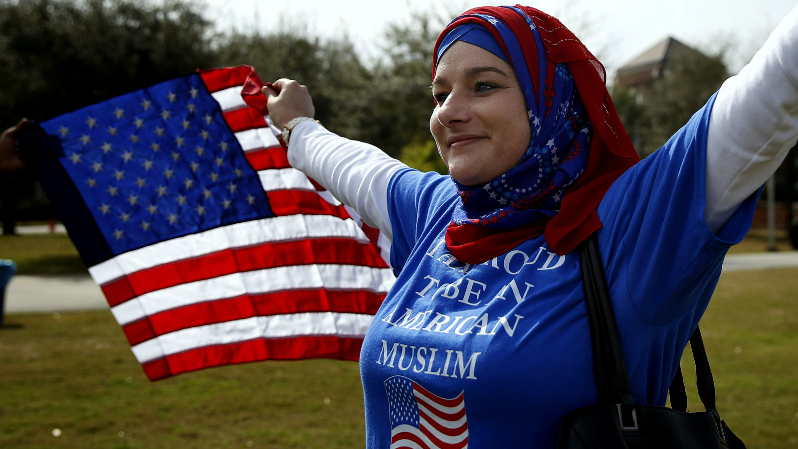 Stacey Miller, holds an America flag, protesting a Donald Trump a campaign rally, Saturday, March 5, 2016, in Orlando, Fla. (AP Photo/Brynn Anderson)