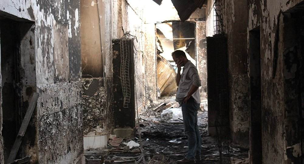 An employee of Doctors Without Borders walks inside the charred remains of the organization's hospital after it was hit by a U.S. airstrike in Kunduz, Afghanistan. More than a dozen U.S. military personnel have been disciplined but face no criminal charges for mistakes that led to the bombing of a Doctors Without Borders hospital in Afghanistan last year that killed 42 Afghans, U.S. defense officials say. (AP Photo/Najim Rahim)