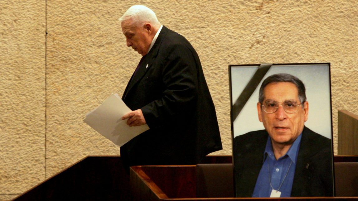 Ariel Sharon walks past a portrait of slain Israeli cabinet minister Rehavam Zeevi, shot and killed by gunmen in Jerusalem in 2001. (AP/Emilio Morenatti)