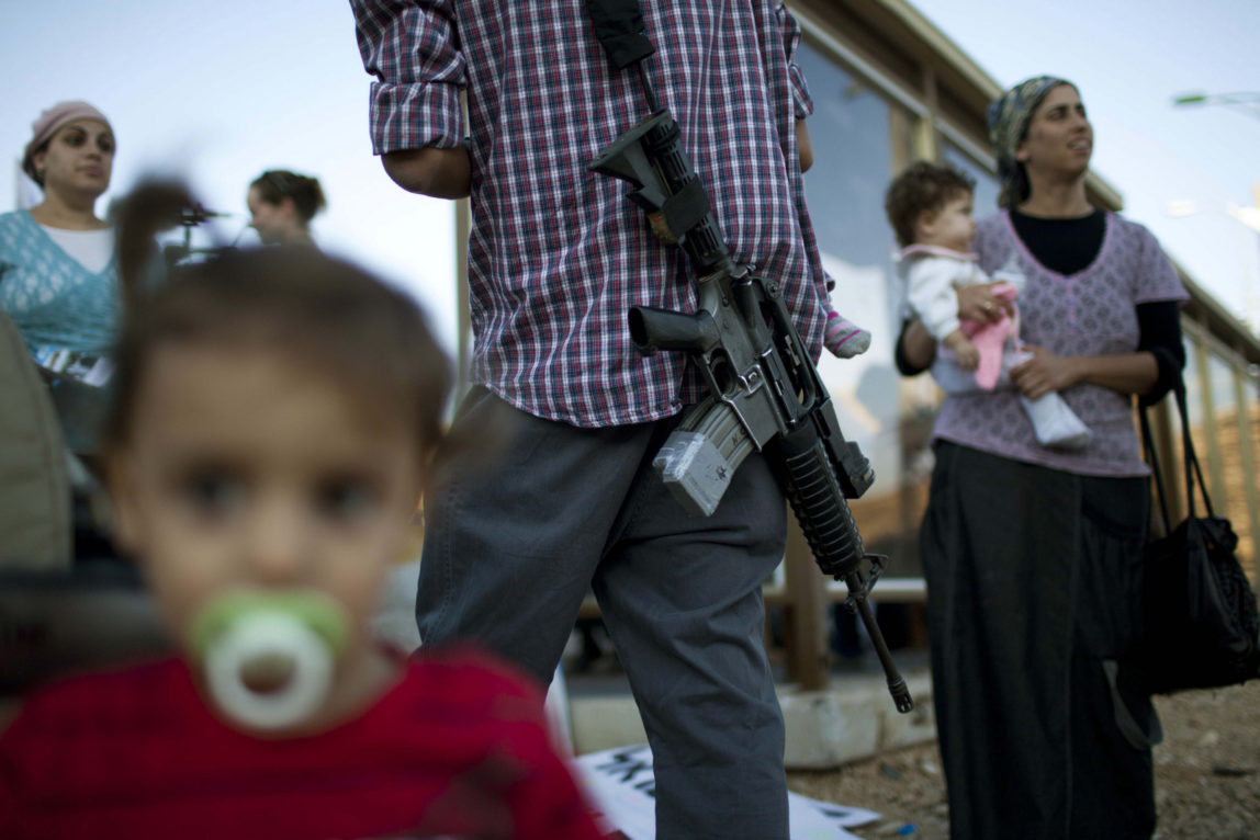 A Jewish settler carries an rifle as he participates in a protest against the Palestinian bid for statehood, outside the Jewish settlement of Kiryat Arba, near the West Bank town of Hebron (A.P Photo/Bernat Armangue)