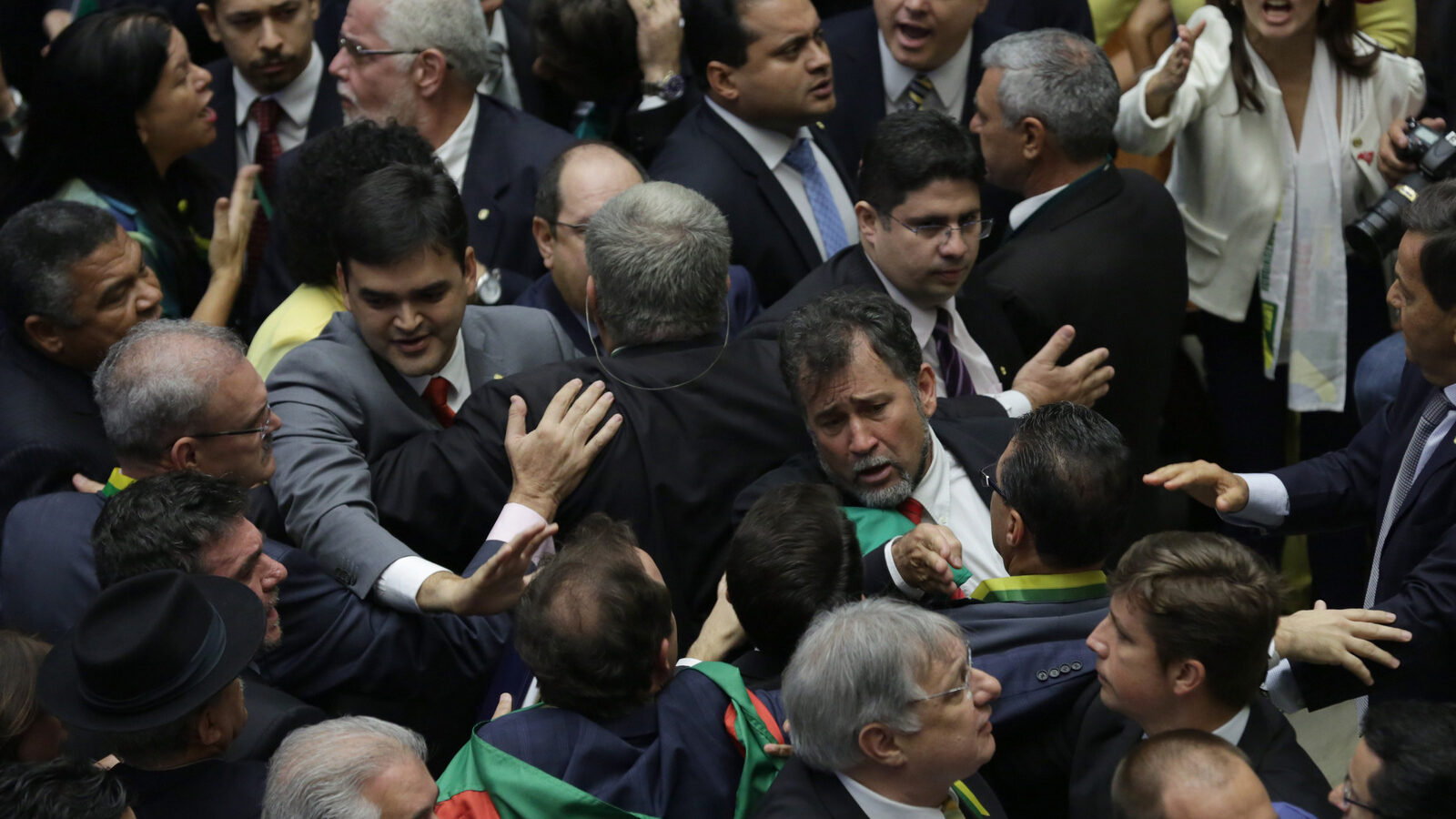 Pro-government lawmakers scuffle with opposition lawmakers during the session on whether or not to impeachment Brazil's President Dilma Rousseff in Brasilia, Brazil, Sunday, April 17, 2016. The vote will determine whether the impeachment proceeds to the Senate. Rousseff is accused of violating Brazil's fiscal laws to shore up public support amid a flagging economy. (AP Photo/Eraldo Peres)