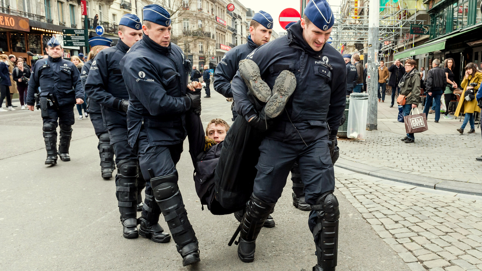 Policemen detain a man at the Place de la Bourse in Brussels, Belgium, after authorities banned all marches in Brussels. (AP Photo/Geert Vanden Wijngaert)