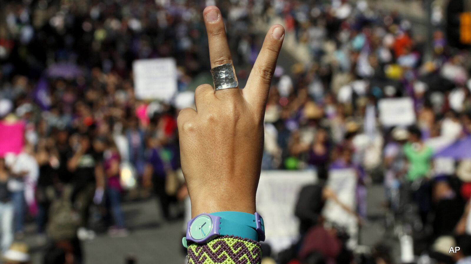 A female demonstrator flashes a victory sign.