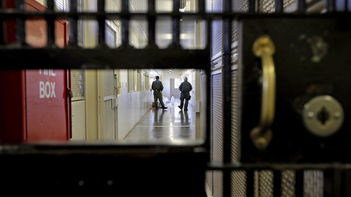 Prison guards walk down a corridor in the Adjustment Center at at a US prison. (AP Photo/Ben Margot)